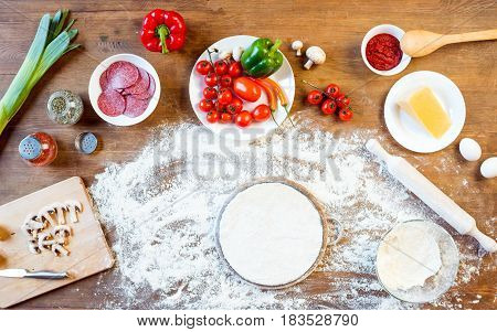 Top View Of Different Pizza Ingredients, Vegetables And Dough On Wooden Tabletop