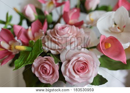 Flowers made from pastry mastic, cake with decorative white, green and pink elements, sugar flowers concept