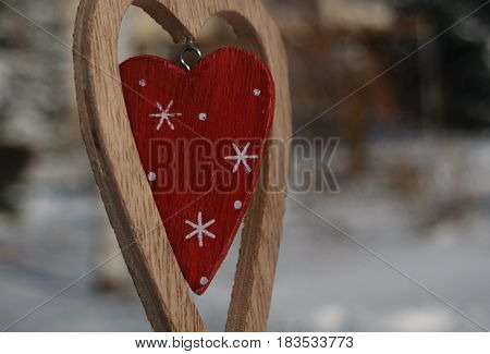 stylish wooden heart with a red heart close up on winter