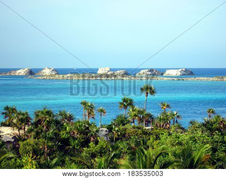 Palm tree fringed island with turquoise crystal clear water