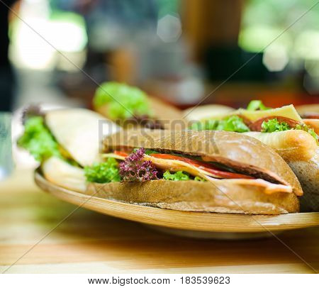 Sandwich with cheese and vegetables on a wooden board with no sharp background