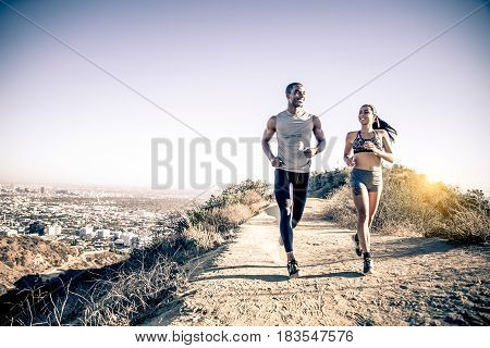 Multi-ethnic couple training in a canyon - Sportive boyfriend and girlfriend running outdoors