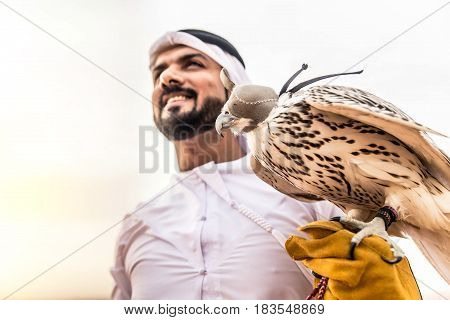 Arabian man walking in the desert at sunrise