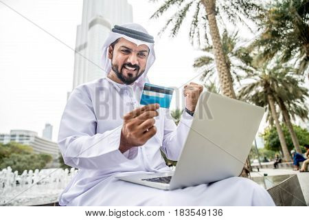 Arabic businessman in Dubai shopping online with laptop