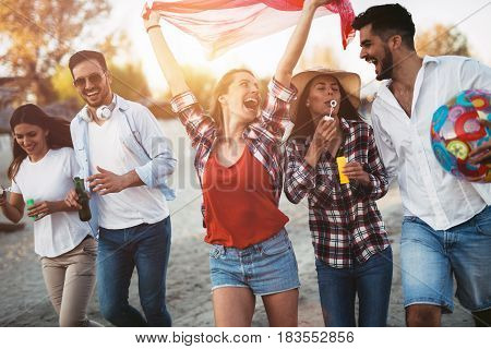 Happy group of young friends having fun on beach in summer