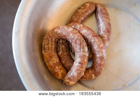 Homemade sausage. Manual manufacturing. Sausage in a large bowl. Soft focus.