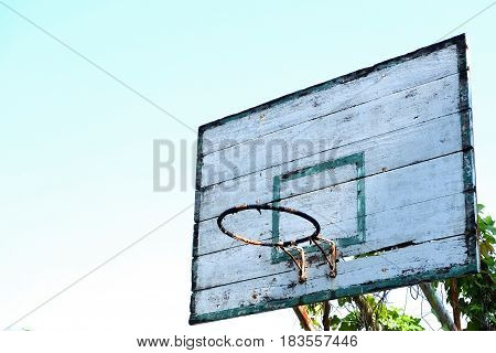 Closeup of old basketball hoop with blue sky background