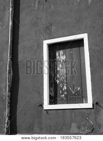 shuttered windows on an old wall with white frame