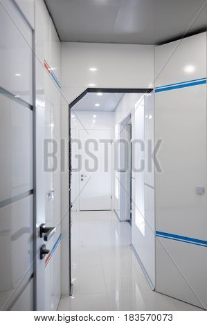Modern home hallway interior. White plactic panels and tiles. Futuristic interior concept design. Space ship at home