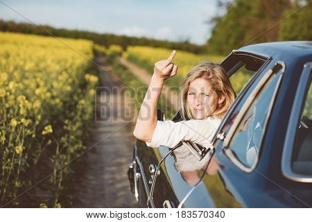 woman is driving her car very aggressive and gives gesture