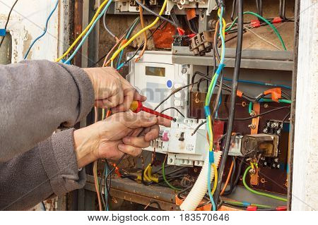 Repair of electricity distribution in an old house. The man repairs the switchboard