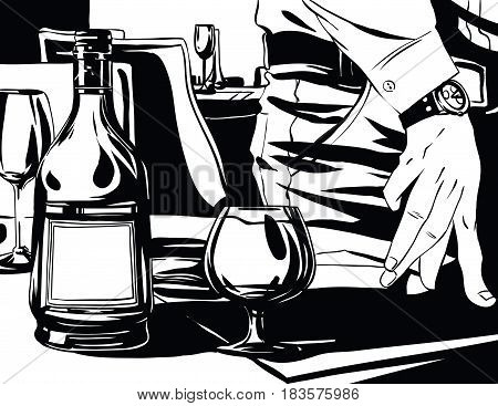 Elegant man's hand next to a glass of brandy