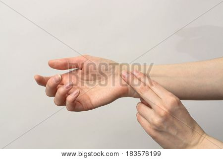 Medicine health care. Female hand checking pulse on wrist closeup.