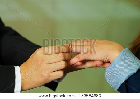 Close up shot of man proposing putting ring on finger of woman