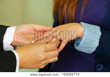 Close up shot of man proposing putting ring on her finger