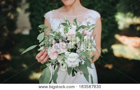 A beautiful wedding bouquet in the hands of the bride.