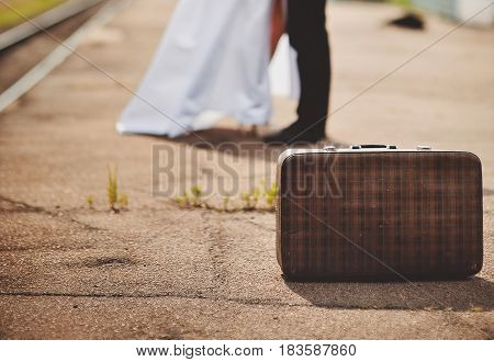 Young loving couple with suitcase on a railway station.