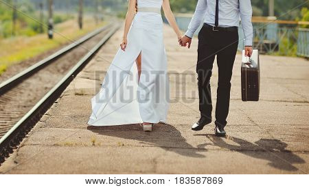 Young loving couple with suitcase on a railway station.