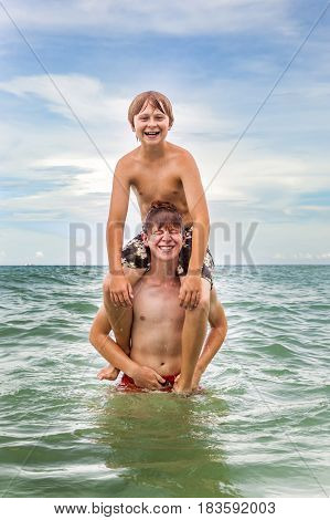 Boys Having Fun In The Beautiful Clear Sea