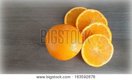 Whole orange and 4 slices on the background derevyanny surface.