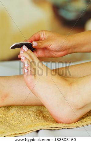 Nail files, foot care. Woman giving herself a pedicure