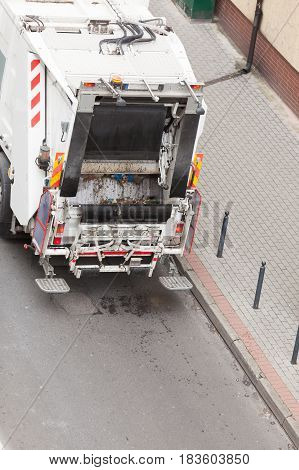 Modern white garbage dustcart truck on city street. Recycling in town concept.