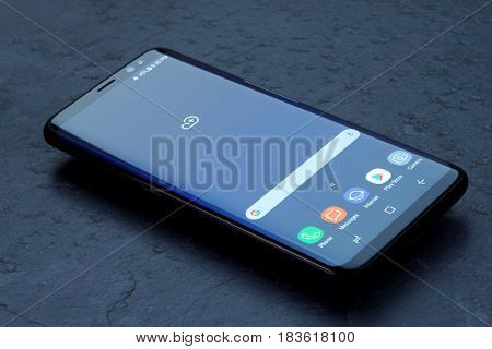 Koszalin, Poland - 25 April, 2017: Black Samsung Galaxy S8 on stone table. Samsung S8 are new generation smartphone from Samsung. The Samsung S8 is smart phone with multi touch screen