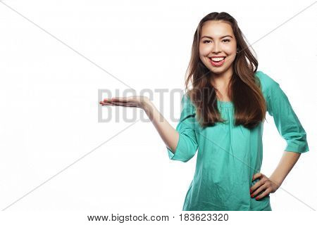 Young smiling woman points a hand with positive facial expressio