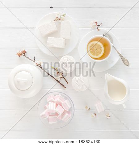 Nice tea ceremony with zefir and marshmellow, lemon with tea and sweets, topview