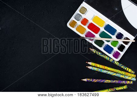 Watercolors And Pencils On A Black Background. Top View. Copy Space.