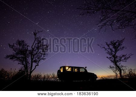 Leningrad region, Russia - April 22, 2017. Jeep Wrangler under the starry sky on the shore of the bay. Wrangler is a compact SUV produced by Chrysler