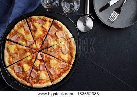 Homemade Pizza With Pineapple And Ham On Dark Blue Stone Table With Tableware.