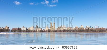 New York City - Panoramic view of modern buildings from Central Park with Jacqueline Kennedy Onassis Reservoir.