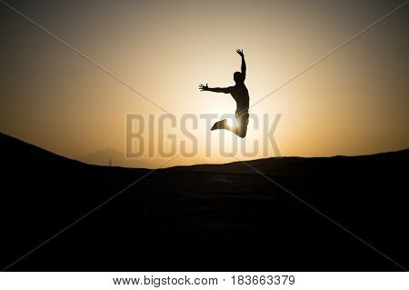 Jumping Man Silhouette At Sunset Sky