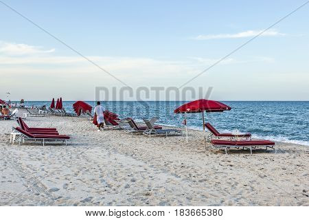 Hotel Boy Collects The Red Divan Beds At South Beach At The End Of The Sunny Day In Miami