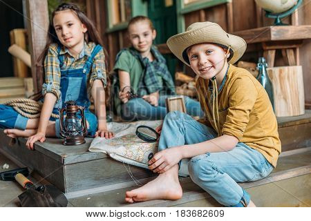 Adorable Little Kids Travelers Sitting Together With Map On Porch