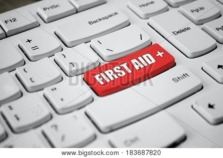 Cross symbol and first aid text on red button of white keyboard.