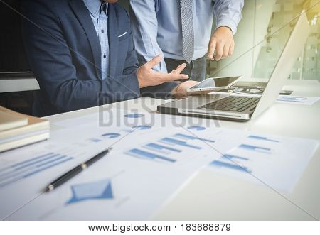 Teamwork process Businessmen hands pointing at tablet laptop and document during explanation of new plan project data at meeting.