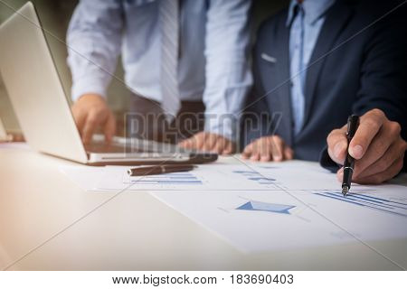 Teamwork process Young businessmen hands pointing at document and laptop during explanation of new plan project data at meeting.