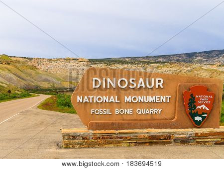 JENSEN USA - MAY 29 2016: Entrance sign of the Dinosaur National Monument and the quarry that contains dinosaur fossils.