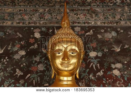 Buddha gold statue in front off old wall