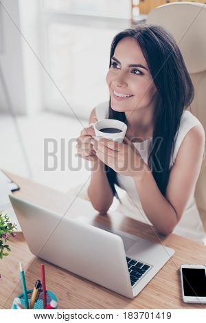 Dreamy Brunette Girl Is Drinking Tea And Imagining The Holiday That Will Be Soon.she Is Smiling And