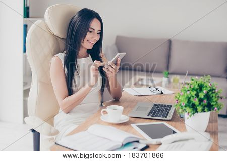 Close Up Portrait Of Young Brunette Woman Typing An Sms On Her Pda While Having A Coffee Break At Wo