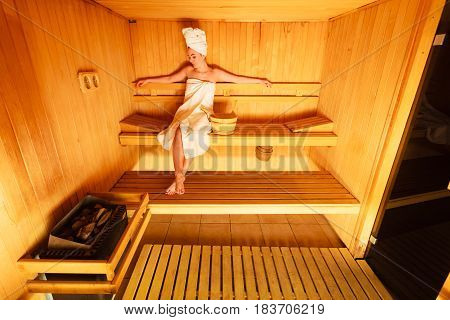 Woman Sitting Relaxed In Wooden Sauna