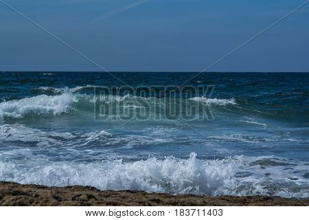 waves breaking into the shore in the late afternoon
