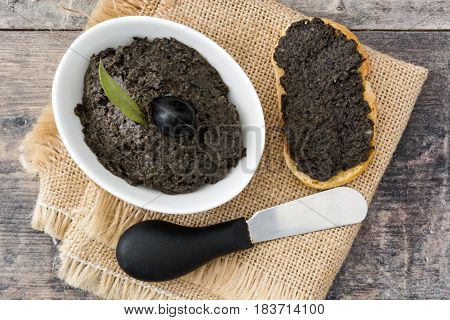 Black olive tapenade with anchovies, garlic and olive oil on wooden table