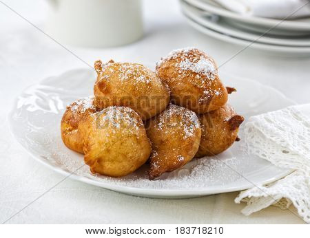 Sweet homemade beignets covered with powdered sugar.