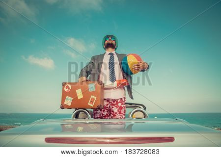 Businessman Standing On A Beach Near Car
