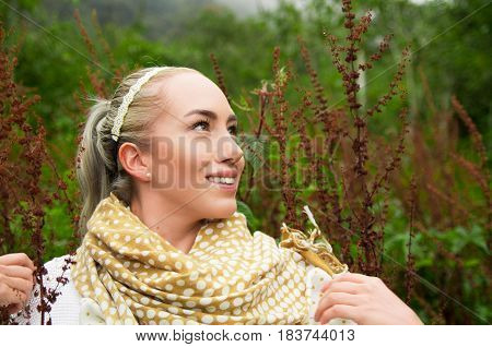 Close up portrait of smiling beautiful woman enjoying nature in a forest