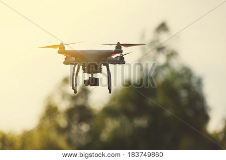 Quadrocopter flies in the air at sunset. Launching a quadrocopter in the park